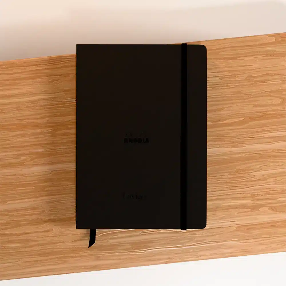 carnet rhodia a5 coloris noir sur support en bois